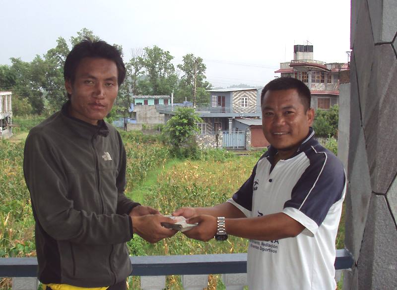 Foto: Heute wurde die Belohnung von 1000 Euro ausgezahlt fr die Finder der sterblichen berreste von Mario Menichetti. Jit Magar (rechts), Direktor von SARDOGS Nepal, berreicht die Belohnung an Subindra K. Pun, einen offiziell legitimierten Abgesandten des Dorfs im Bezirk Rukkum, aus dem die vier Finder (eine Frau und drei Mnner) stammen. Sie hatten Ende Mai Mario in einer abtauenden Schneewchte entdeckt und sofort die lokale Polizei informiert. Today, Executive Director of SARDOGS Nepal Jit Magar handed out the reward over 1000 Euros to Mr. Subindra K. Pun for finding the human remains of Mario Menichetti. Mr. Pun is officially legitimized by the police and village head office in Rukkum district where the four finders of Mario came from. These finders are one woman and three man. They discovered the body in a melting snowdrift and informed the local police immediately.